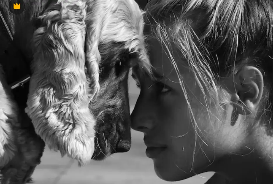 Femme front contre front avec son chien, en noir et blanc