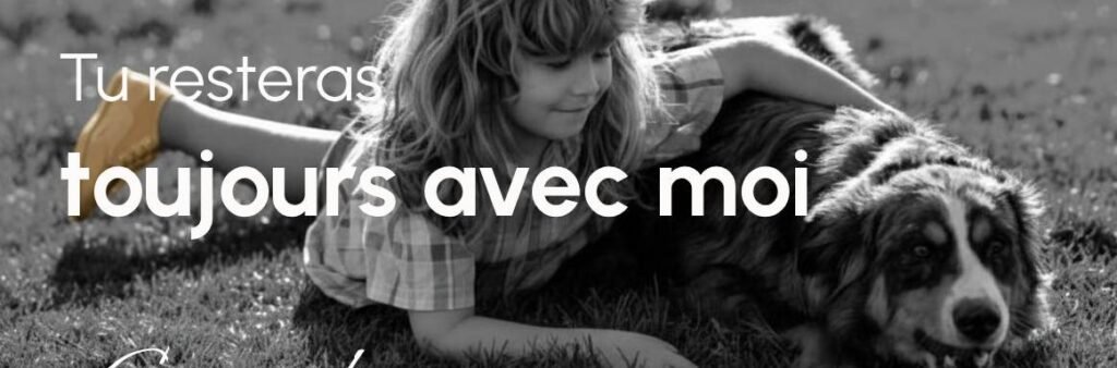 Petite fille allongée dans l'herbe avec son chien à ses côtés, illustration de l'attachement inconditionnel et du souvenir de l'animal.